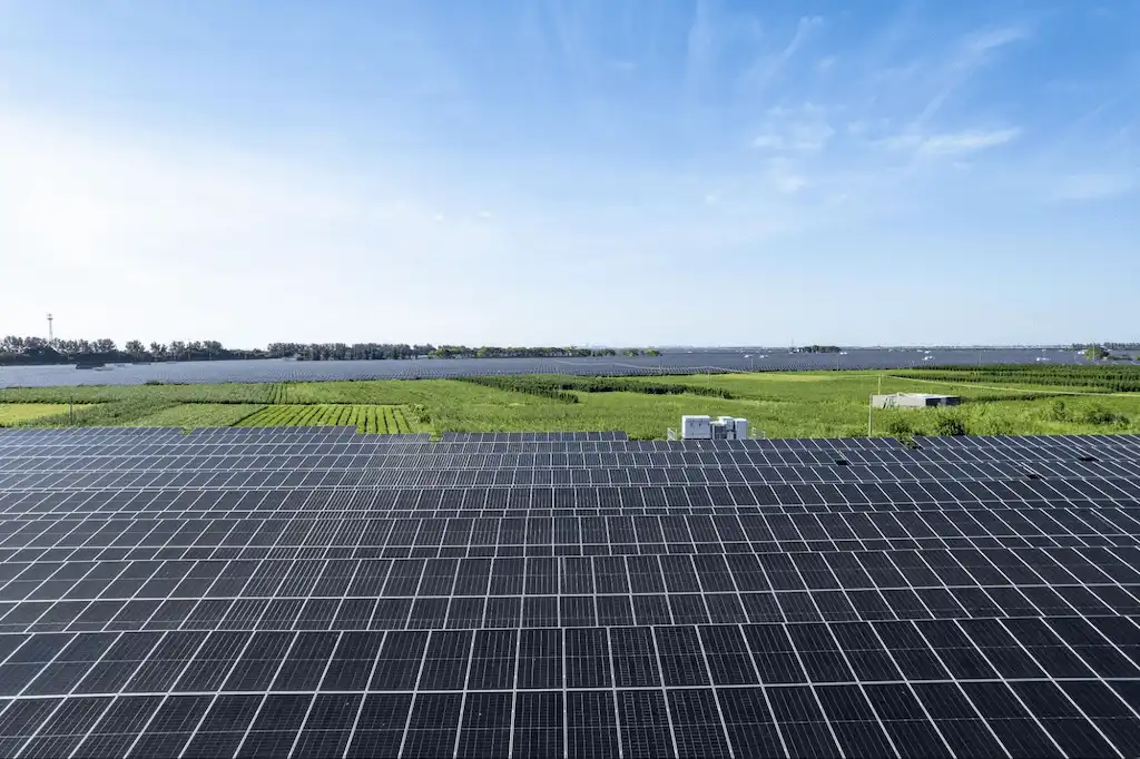 Painéis solares em funcionamento em usina solar, com equipamentos de suporte para manutenção e monitoramento de energia renovável.