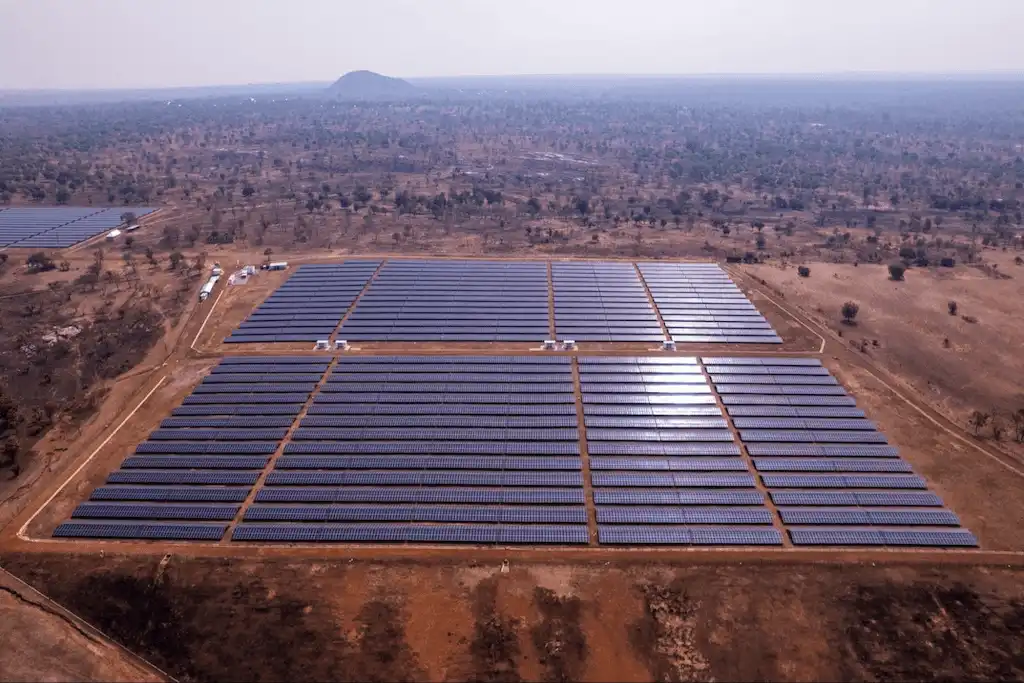 Campo extenso de painéis solares organizados em fileiras, gerando energia fotovoltaica em larga escala.