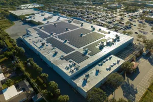 Pavilhão grande de empresa com diversos painéis de energia solar no telhado